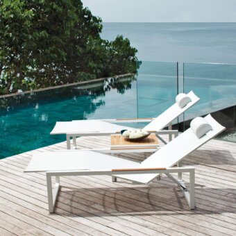 Distinguished Royal Botania Ninix lounger with stainless steel frame, warm teak wood armrests and crisp white Batyline seat in a matte finish