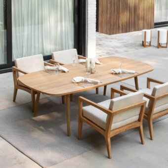 Elegant Royal Botania Styletto table with elliptical teak wood top and tapered teak legs exhibiting a smooth finish