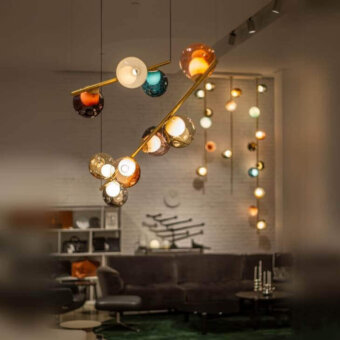 Captivating Bocci 28 Stem suspension lamp with hand-blown glass spheres in amber, orange, white, and teal, built with an unlacquered brass stem