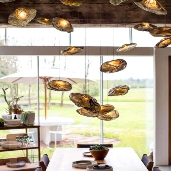 Captivating Bocci 73 suspension lamp presents hand-blown glass pendants within a folded ceramic vessel emitting a warm amber glow