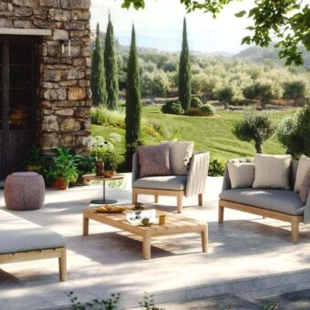 Sophisticated Royal Botania Calypso lounge sofa with teak base and light gray ribbed textile upholstery complemented by brownish-purple cushions