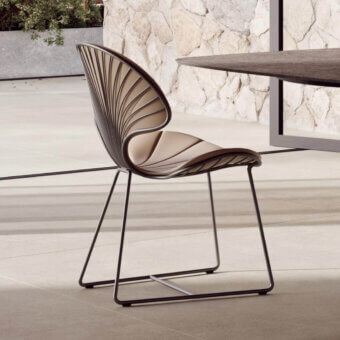 Luxury Royal Botania Ostrea chair with light beige textile seat and backrest contrasted by a dark metal frame, showcasing an oyster-inspired silhouette