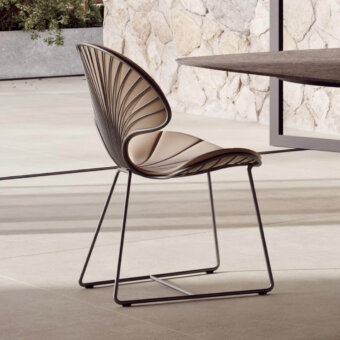 Luxury Royal Botania Ostrea chair with light beige textile seat and backrest contrasted by a dark metal frame, showcasing an oyster-inspired silhouette