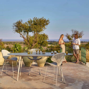 Elegant Royal Botania Styletto table stool with oval teak wood top and light grey woven material in matte white coated aluminum