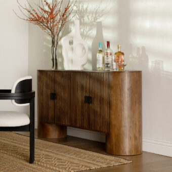 Sideboard by Dovetail Stephenson in brown mango wood with warm-toned finish vertical fluting curved panels matte black hardware pulls
