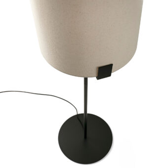 Floor lamp by Faro Barcelona featuring textured off white fabric drum shade, slender metal stem, matte black finish and flat…