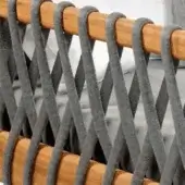 Woven chair back, gray olefin cords, honey-brown wood dowels, diagonal grid pattern, textured surface, durable construction, neutral gray background.