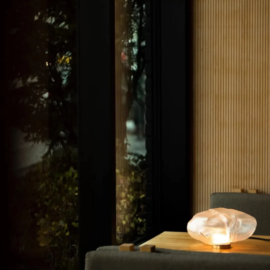 Lamp by Bocci featuring an organic glass diffuser with frosted finish resting on a cylindrical brass metal base