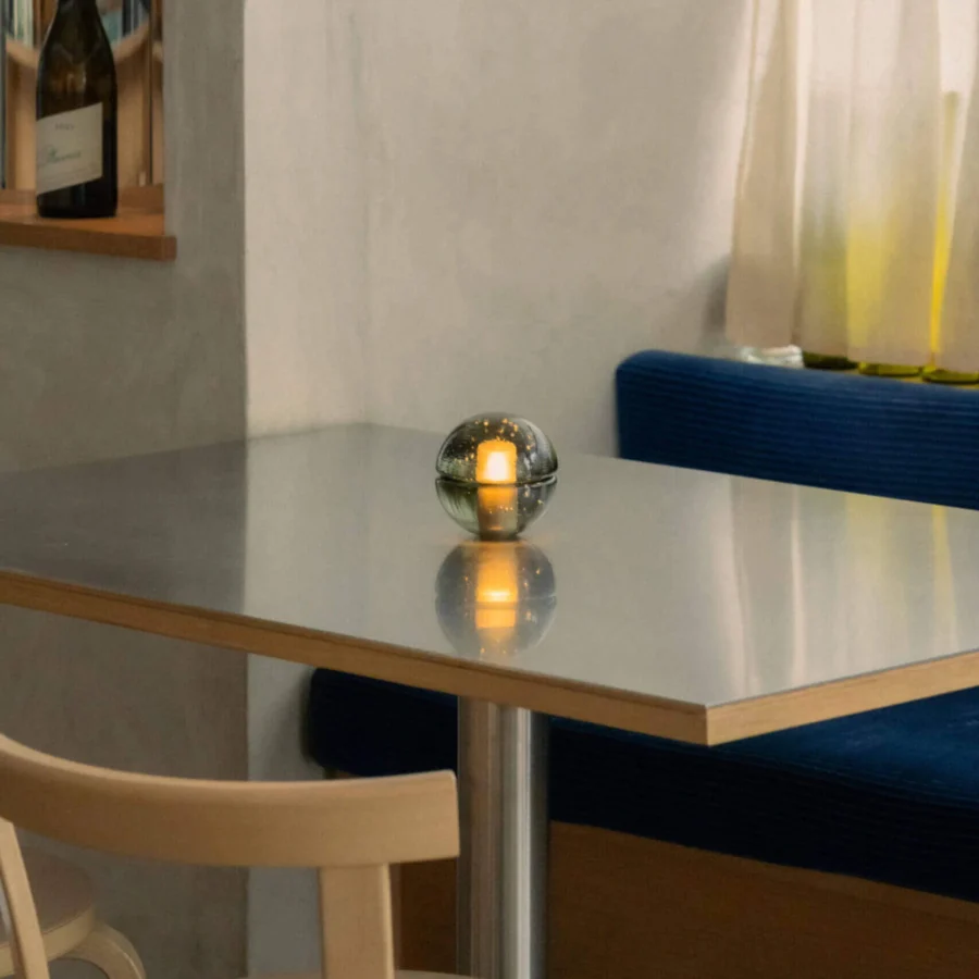 Lamp by Bocci in translucent dark greenish grey glass with glossy finish and spherical shade housing internal battery