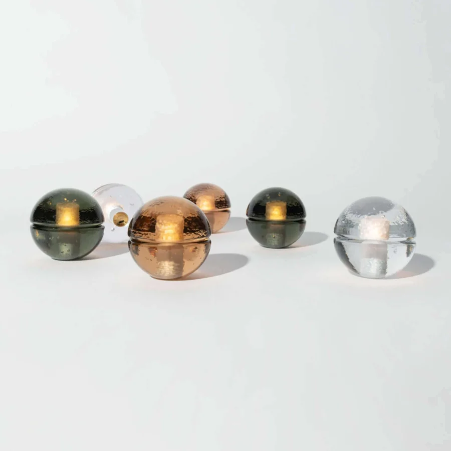 Lamp set by Bocci in clear, dark green, amber glass with glossy finish and horizontal seams on cordless spherical bases