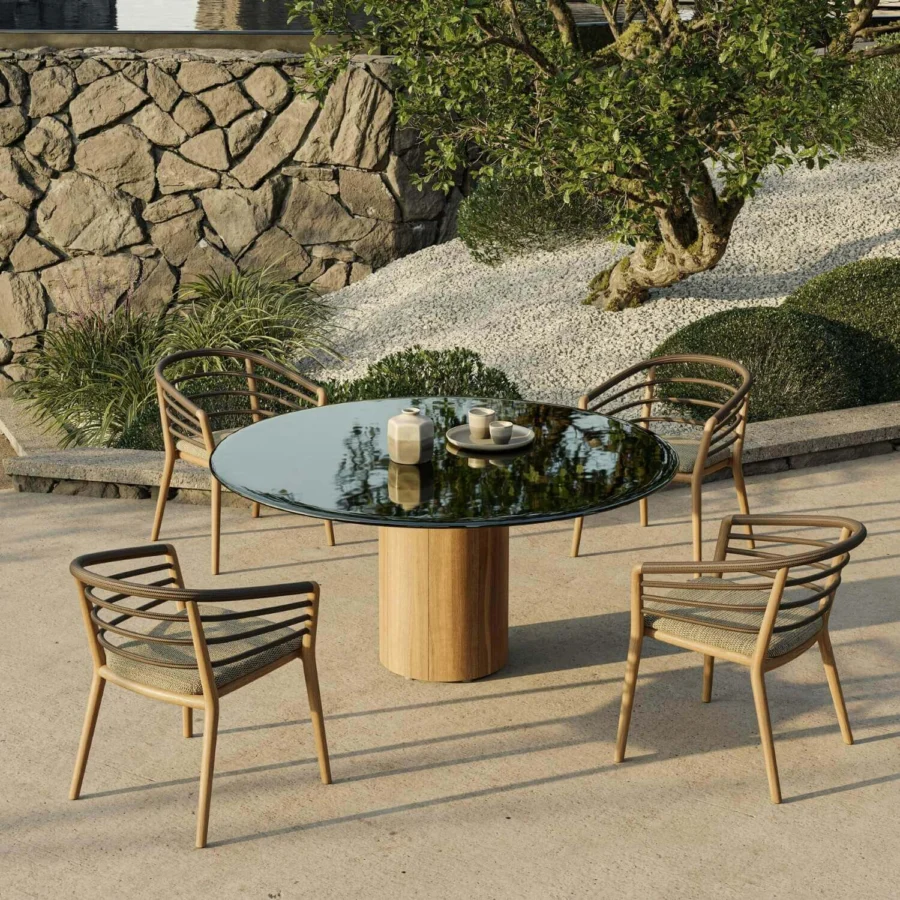 Table by Royal Botania Regaliz featuring dark glass top, vertically paneled wood base, and central cylindrical pedestal