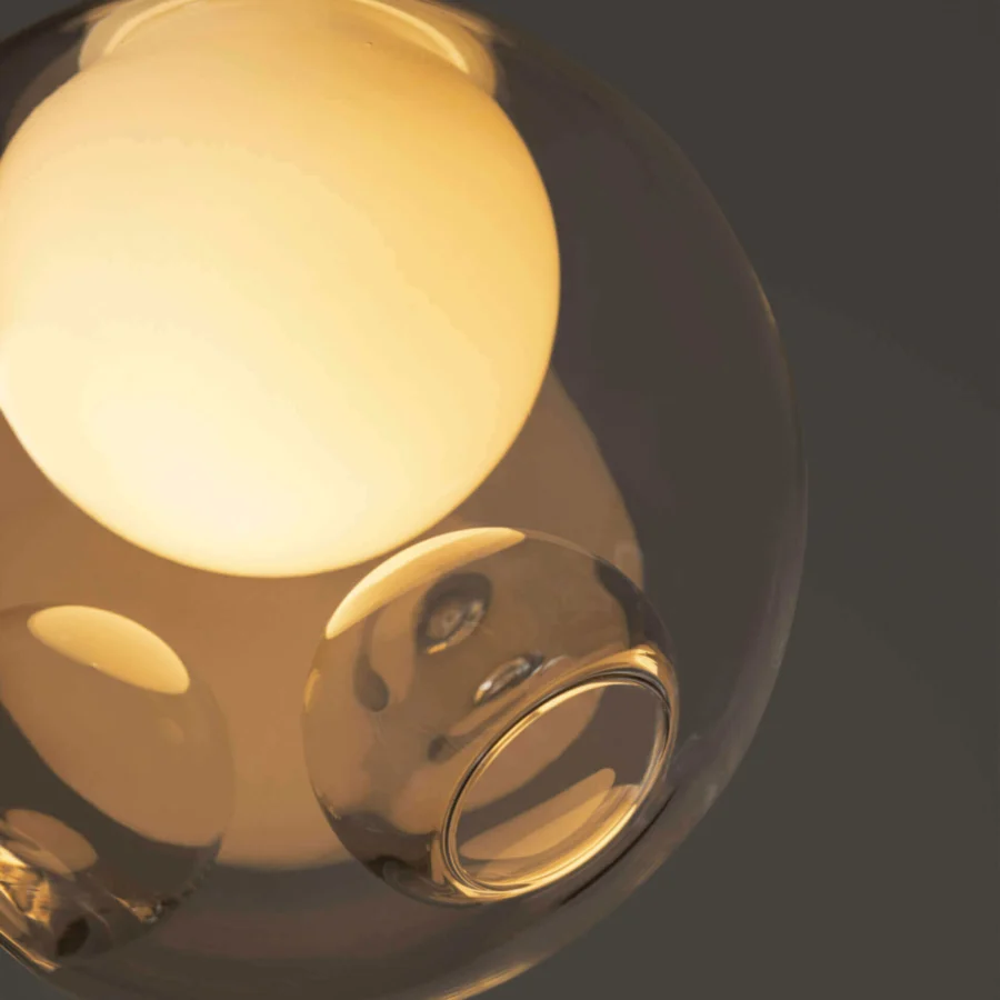 Distinguished Bocci 28 single suspension lamp crafted in clear glass with a warm amber tone and milk white interior