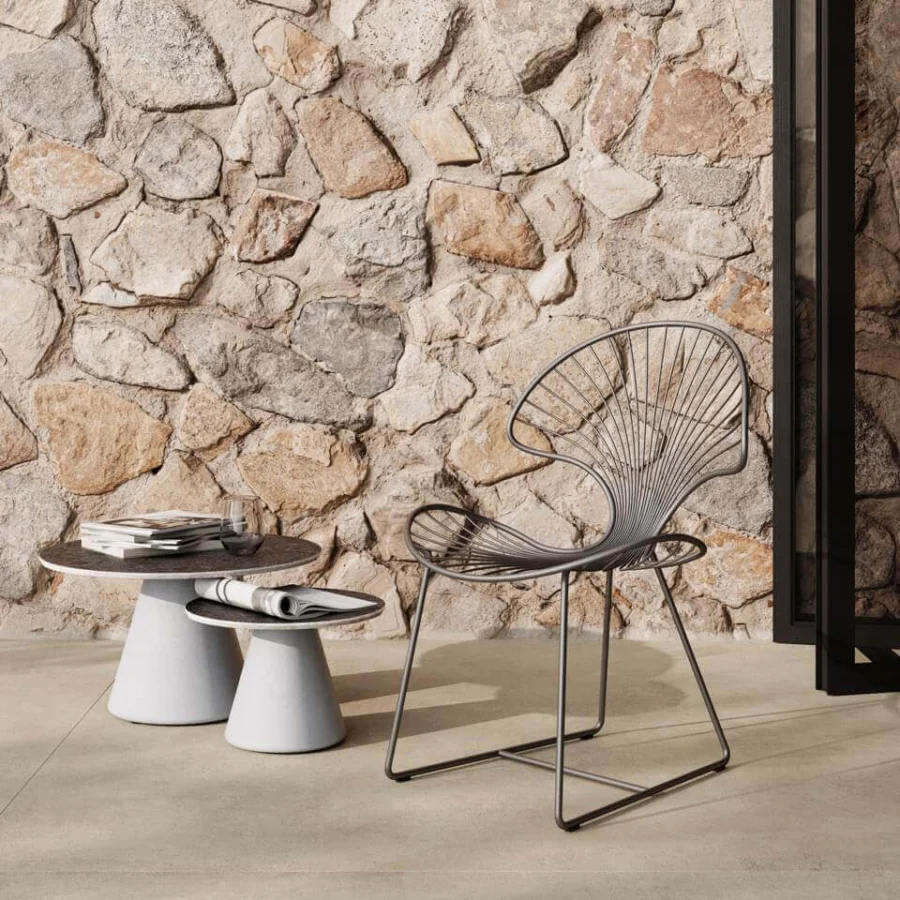 Comfortable Royal Botania Ostrea chair in dark gray coated stainless steel, with a curved silhouette and ergonomic design for outdoor dining