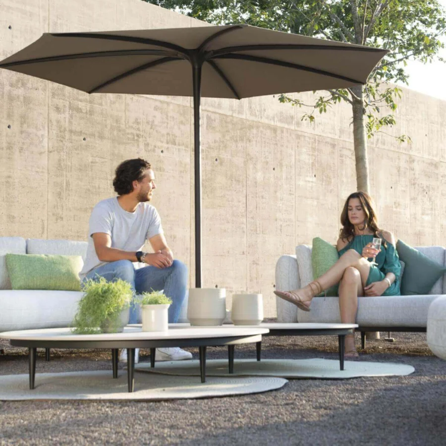 Elegant Royal Botania Organix Lounge sectional with kidney shapes and light grey cushions accented by stylish green pillows with a dark aluminum base