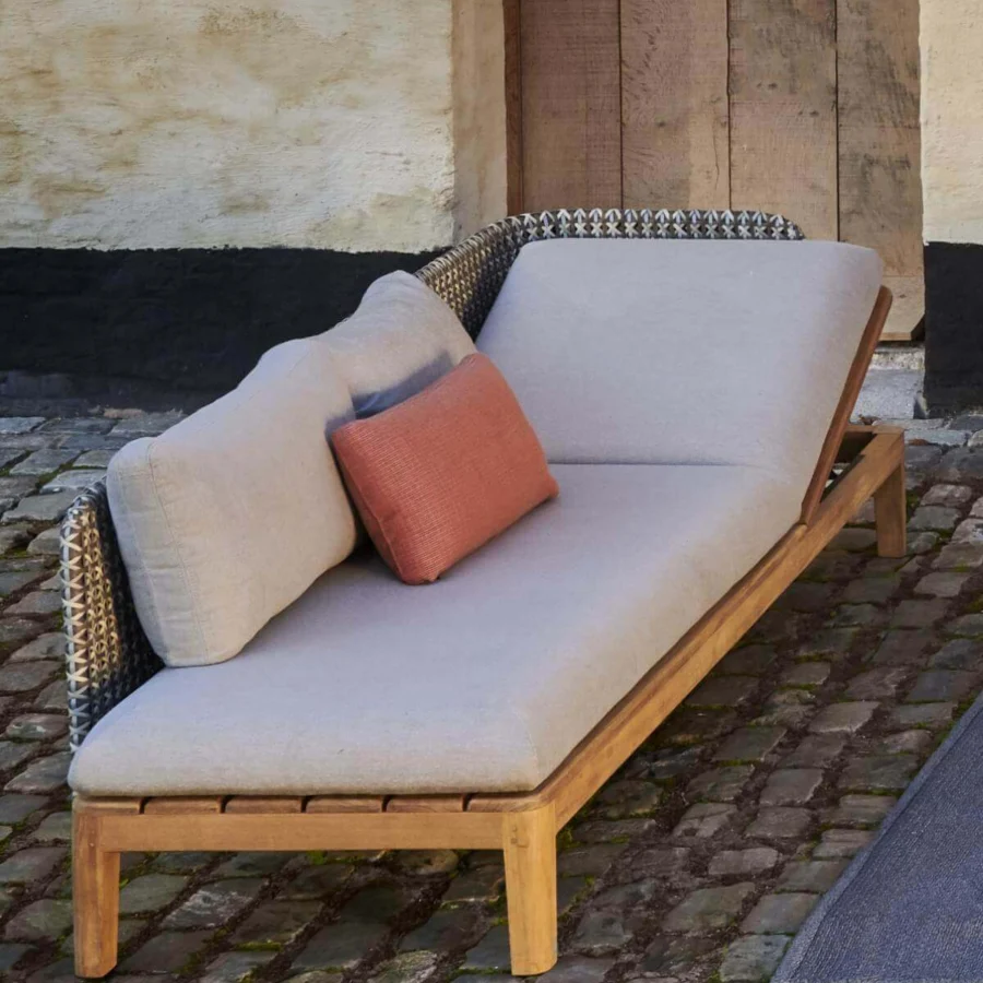 Elegant Royal Botania Calypso lounge lounger with a reclining teak base and stainless steel backrest upholstered in light gray textile