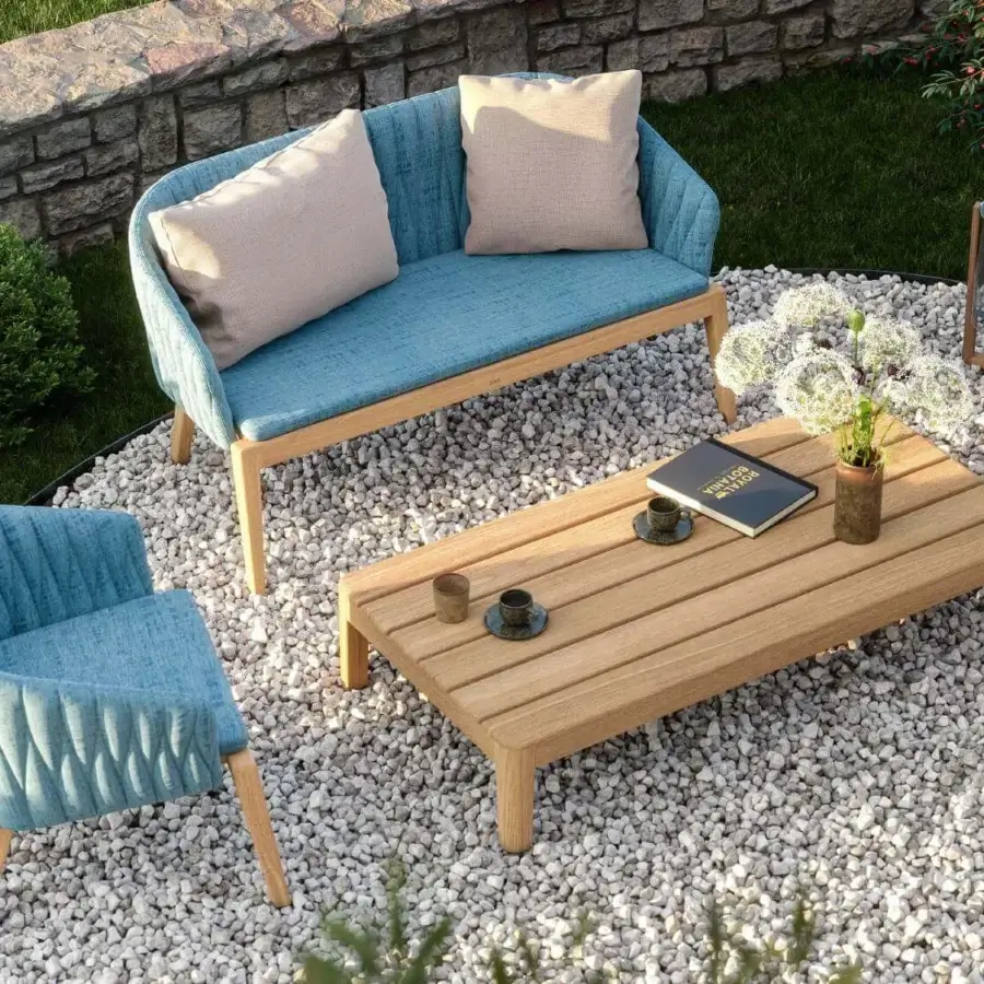 Elegant Royal Botania Calypso lounge chair with textured light blue textile upholstery and refined teak base