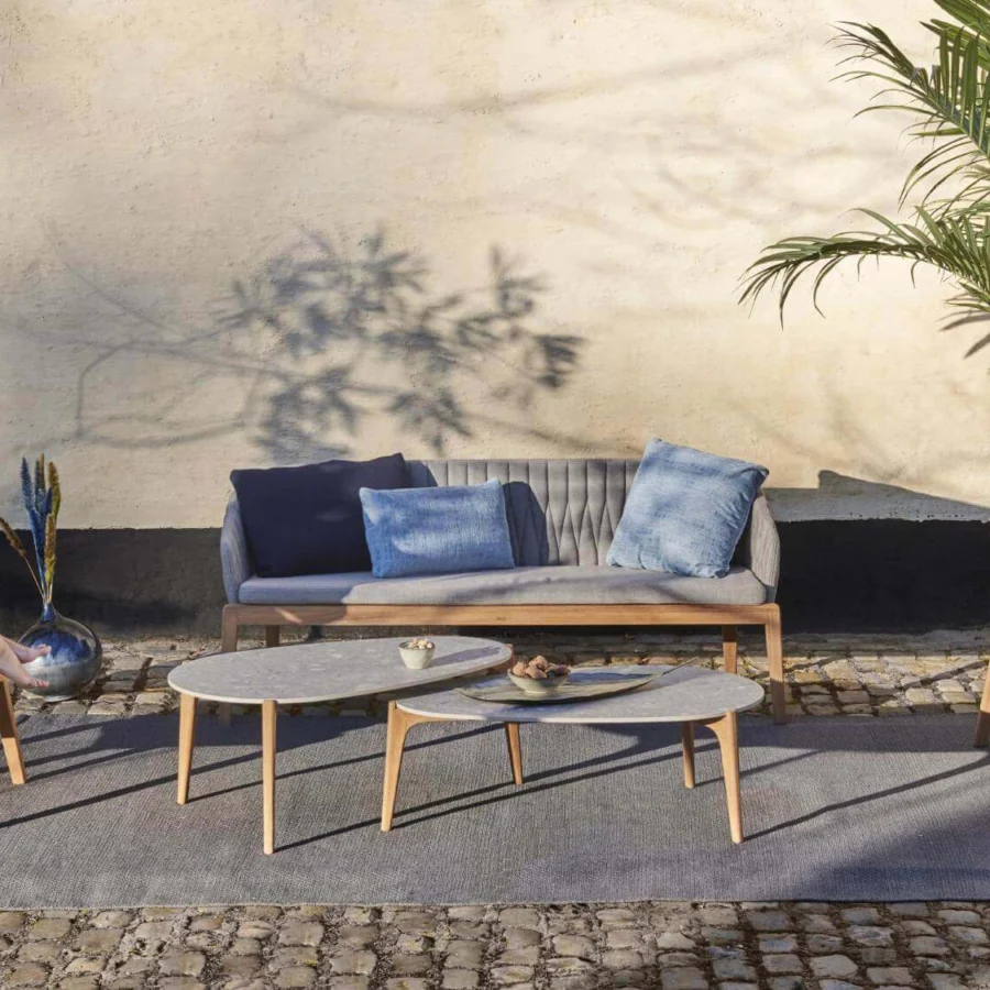 Elegant Royal Botania Calypso lounge chair with teak base, quilted light gray textile upholstery and stainless steel backrest