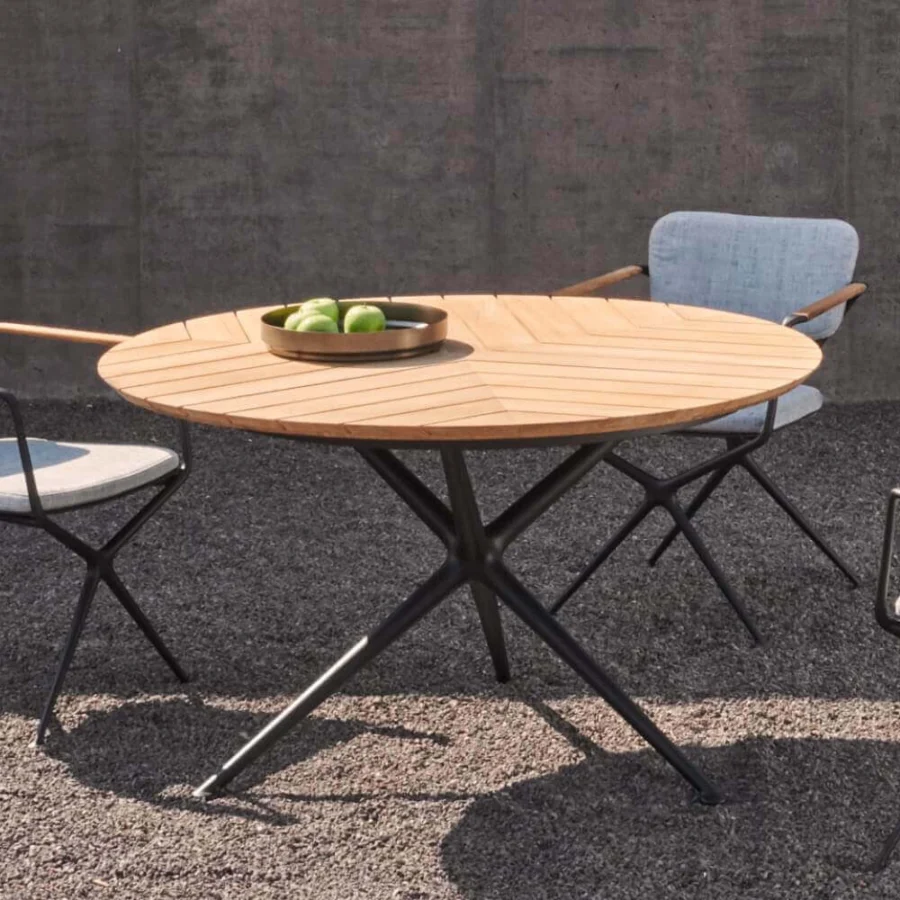 Distinguished Royal Botania Exes table with teak wood tabletop exhibiting a chevron pattern and sleek matte black coated aluminum legs