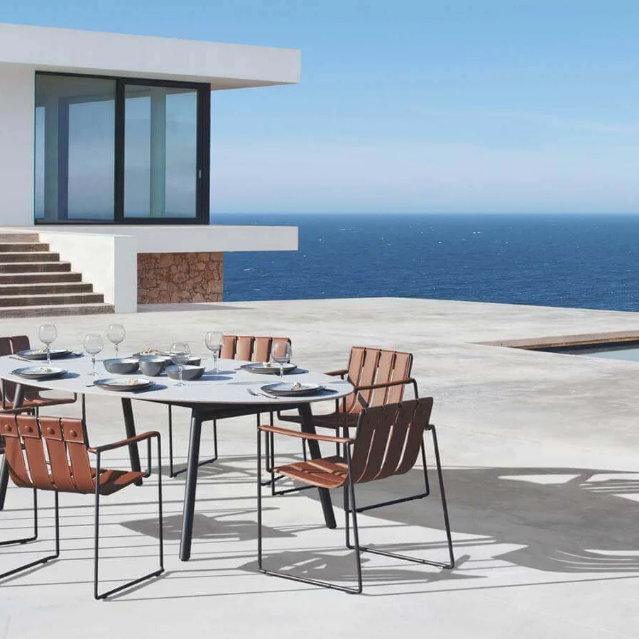 Distinguished Royal Botania Styletto table with a round teak wood top and tapered coated aluminum legs