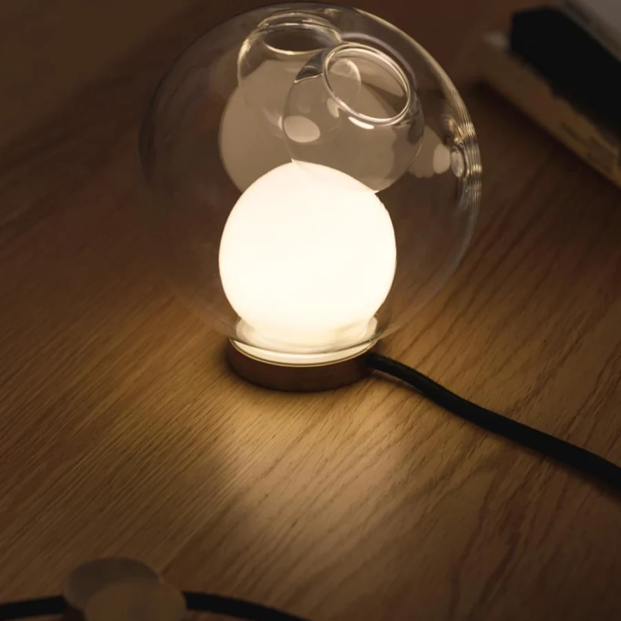 Distinguished Bocci 28 table lamp with clear blown glass shade and warm-toned brass base crafted with a black flexible cord