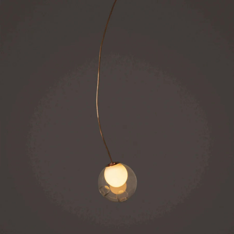 Distinguished Bocci 28 single suspension lamp with gracefully curved form in clear glass and natural copper exhibiting evolving patina