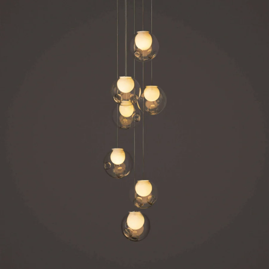 Distinguished Bocci 28 Random suspension lamp crafted with clear glass exterior and milk white interior lamp holder cavities exhibiting a cascading arrangement