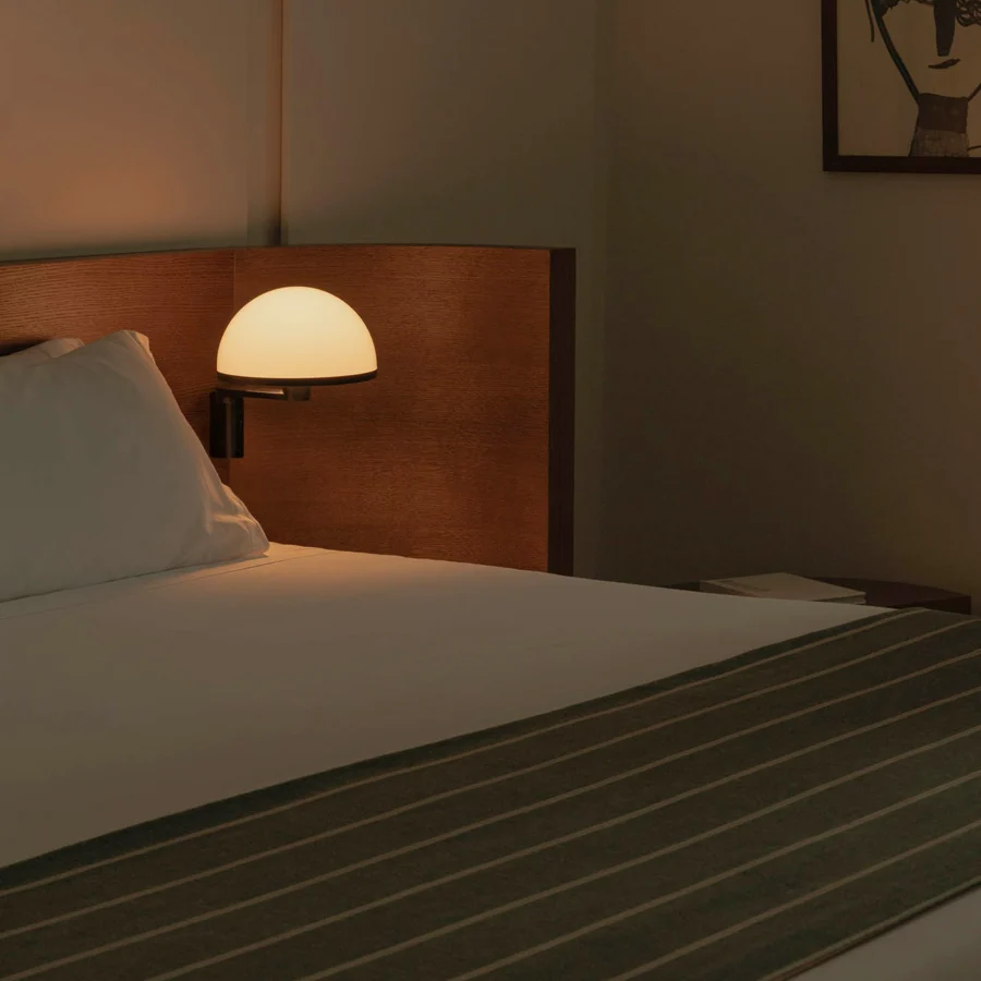 Wall lamp by Faro Barcelona featuring a matte black metal arm and white opaline dome diffuser