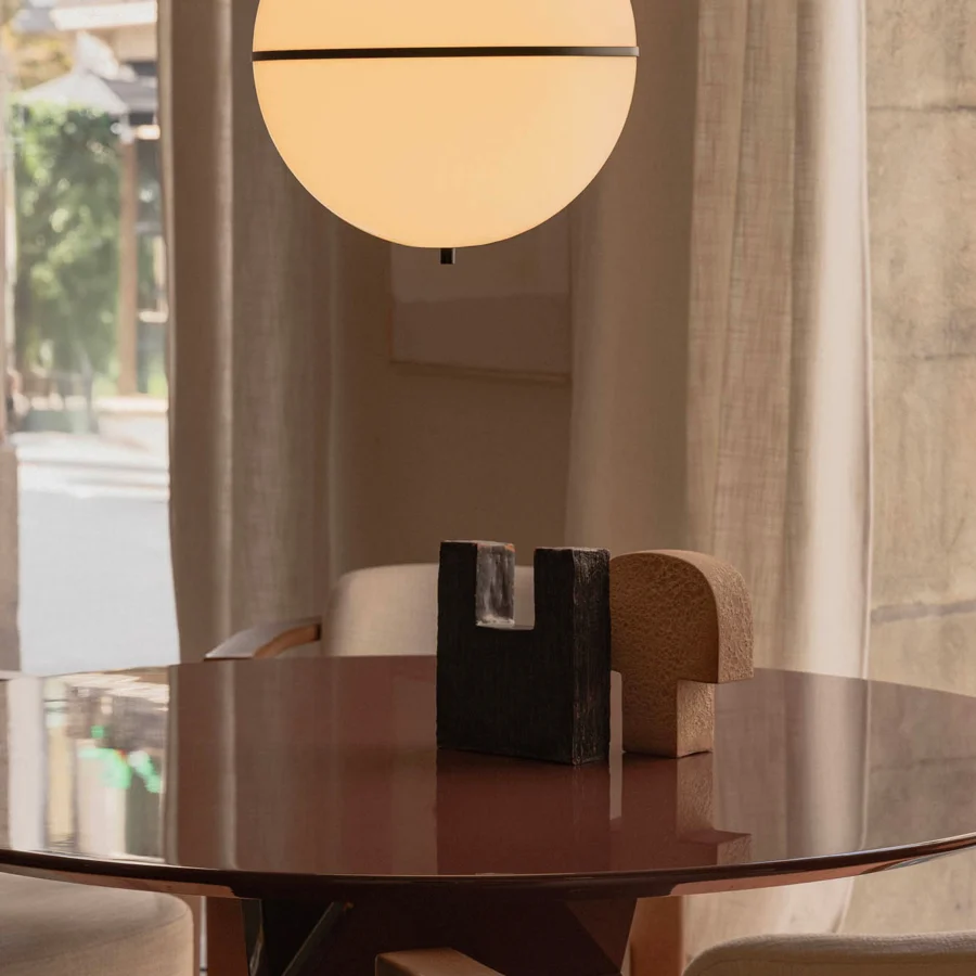 Lamp by Faro Barcelona in translucent glass with matte finish and dark metal band hanging from vertical rod