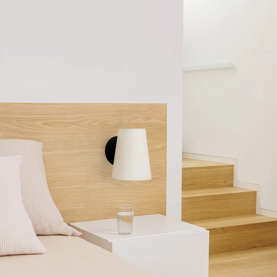 Wall lamp by Faro Barcelona featuring conical textile shade paired with circular steel mounting plate in black finish
