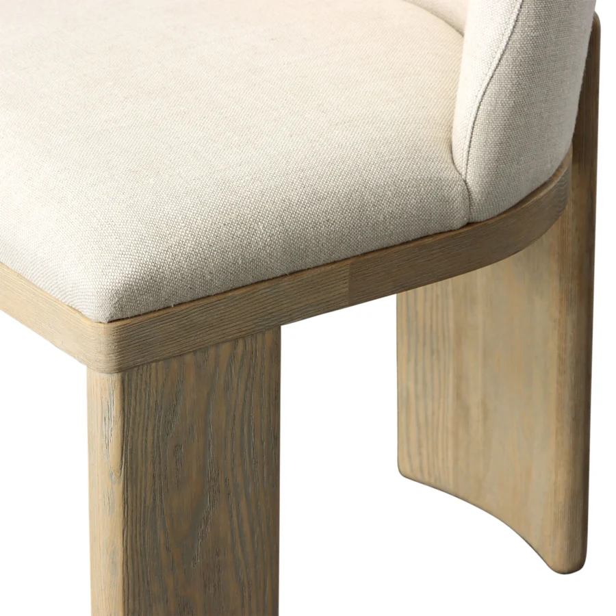 Dining chair by Dovetail in beige linen upholstery with a light warm wash ash wood frame showcasing a matte natural…