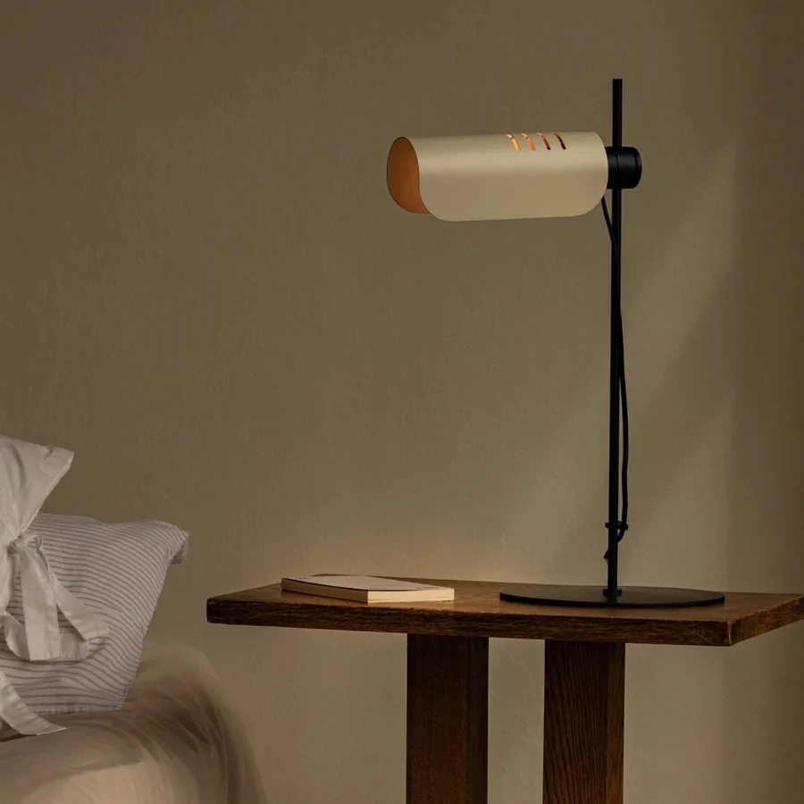 Table lamp by Faro Barcelona in matte black metal with an off-white cylindrical shade and warm golden-yellow interior