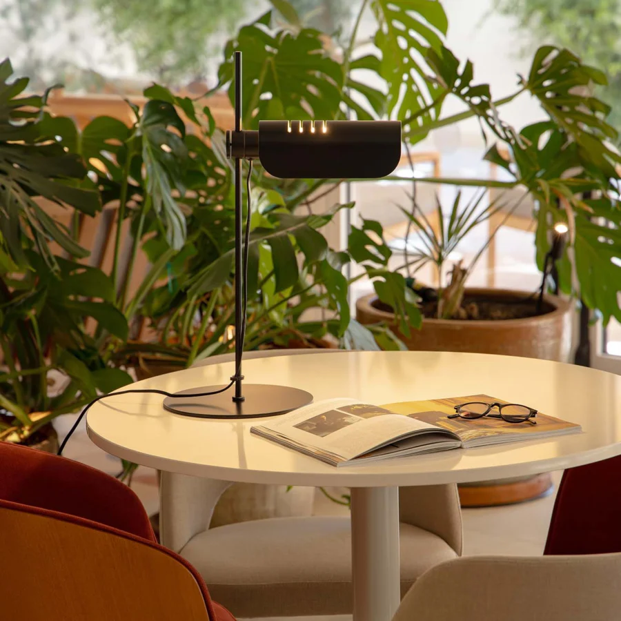 Table lamp by Faro Barcelona in matte black metal with slim vertical stem and adjustable horizontal cylindrical shade