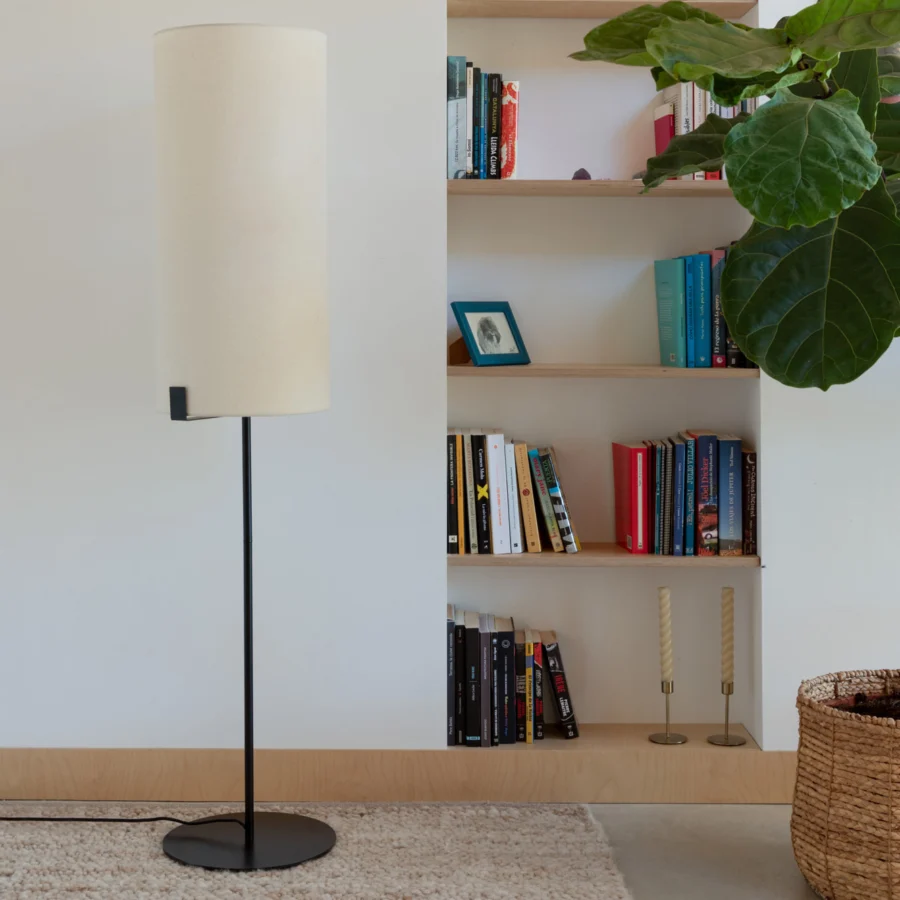 Floor lamp by Faro Barcelona with tall metal stem in matte black finish and cylindrical fabric shade in off-white color