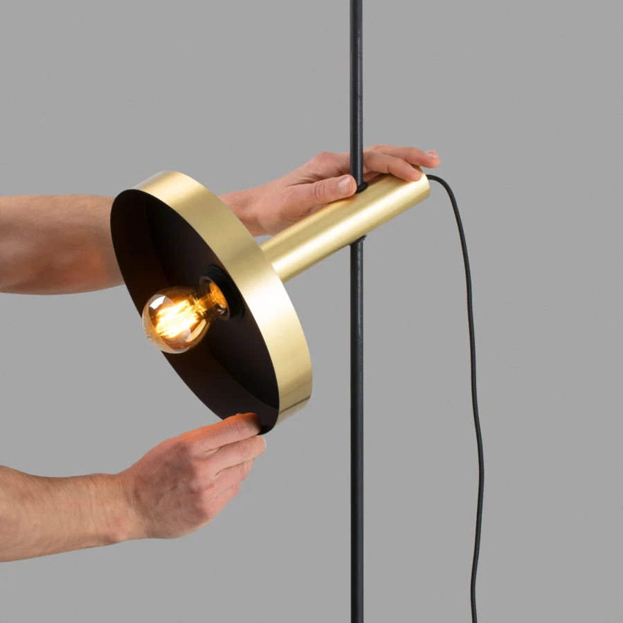 Floor lamp by Faro Barcelona with brushed gold cylindrical metal shade and matte black vertical support rod Edison bulb