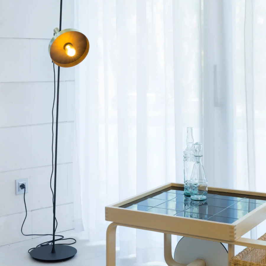 Floor lamp by Faro Barcelona with metal stem, circular base, matte black finish and adjustable drum shade golden yellow
