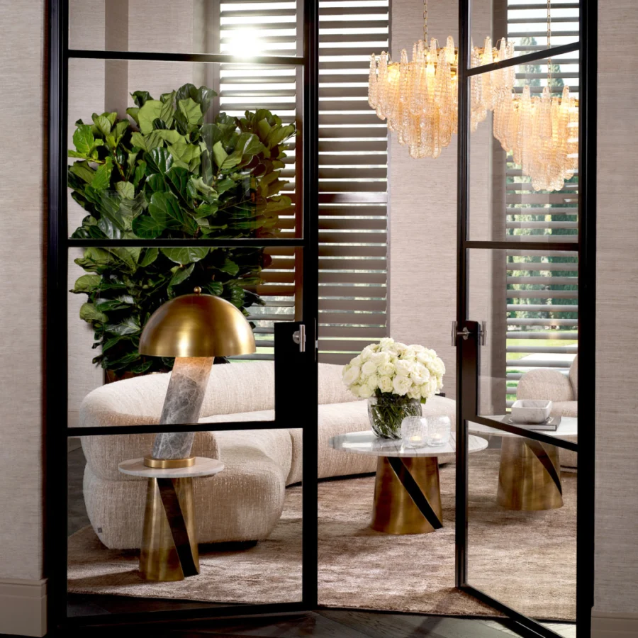 Coffee table by Eichholtz Nuova in white marble with grey veining on a sculptural pedestal base in vintage brass finish