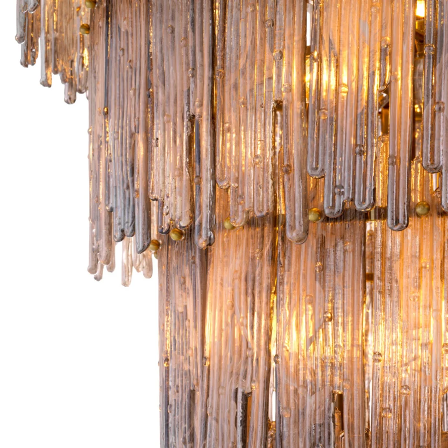 Chandelier by Eichholtz with a brushed brass frame and smoked glass drops in a multi tiered silhouette