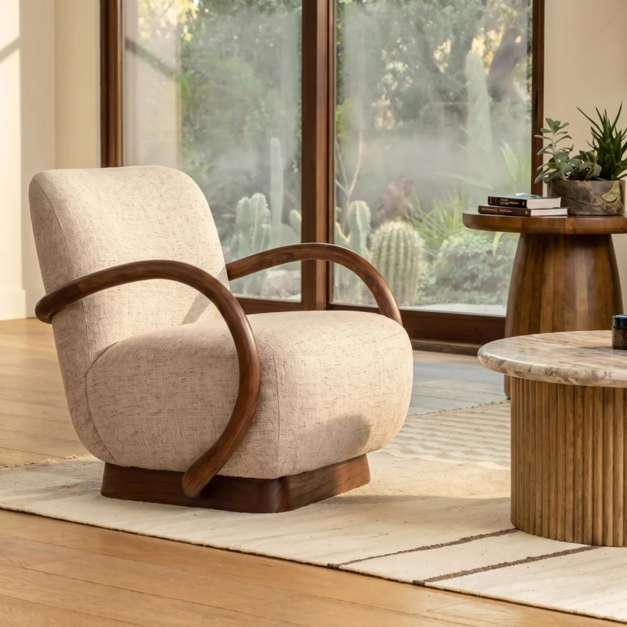 Occasional chair by Dovetail in light beige textured fabric with a natural wood frame and looping armrests